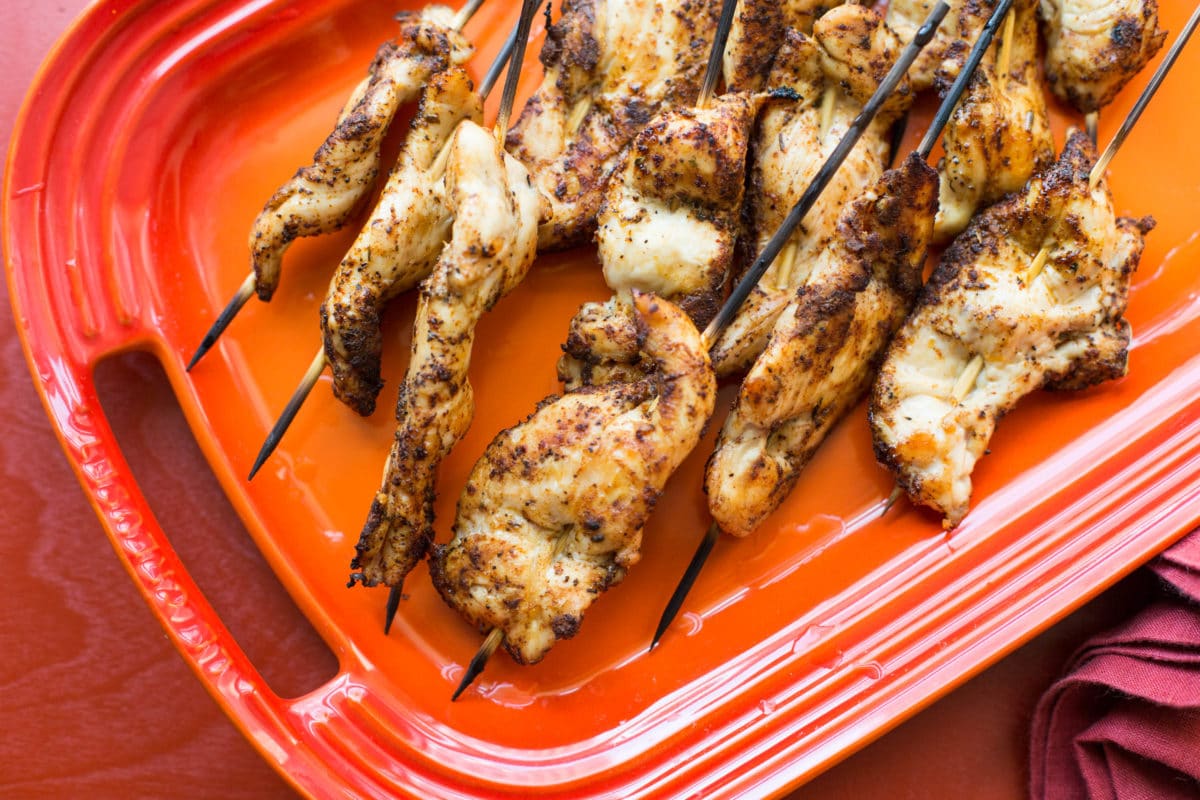 Several Chicken Tender Skewers with Spiced Curry Rub on a platter.