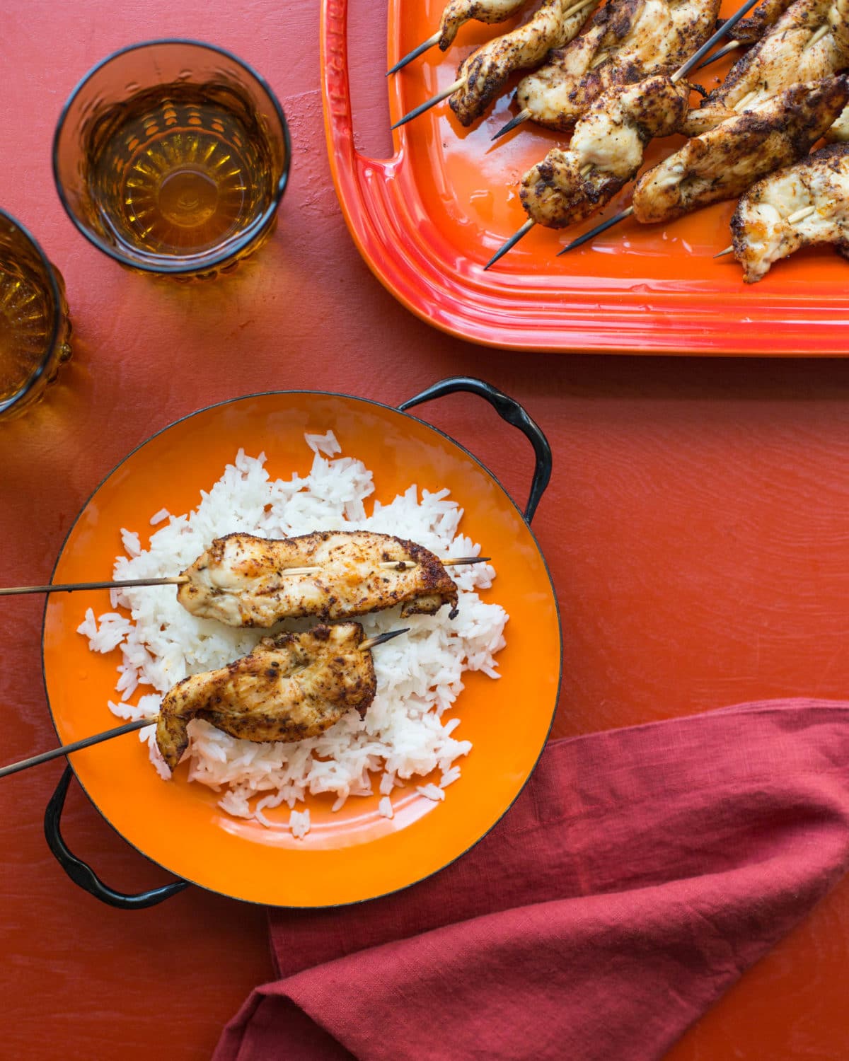 Chicken Tender Skewers with Spiced Curry Rub on a platter and over rice.