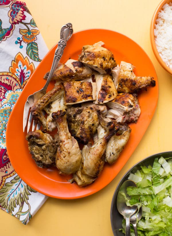 Cut up Rotisserie Chicken on an orange platter.