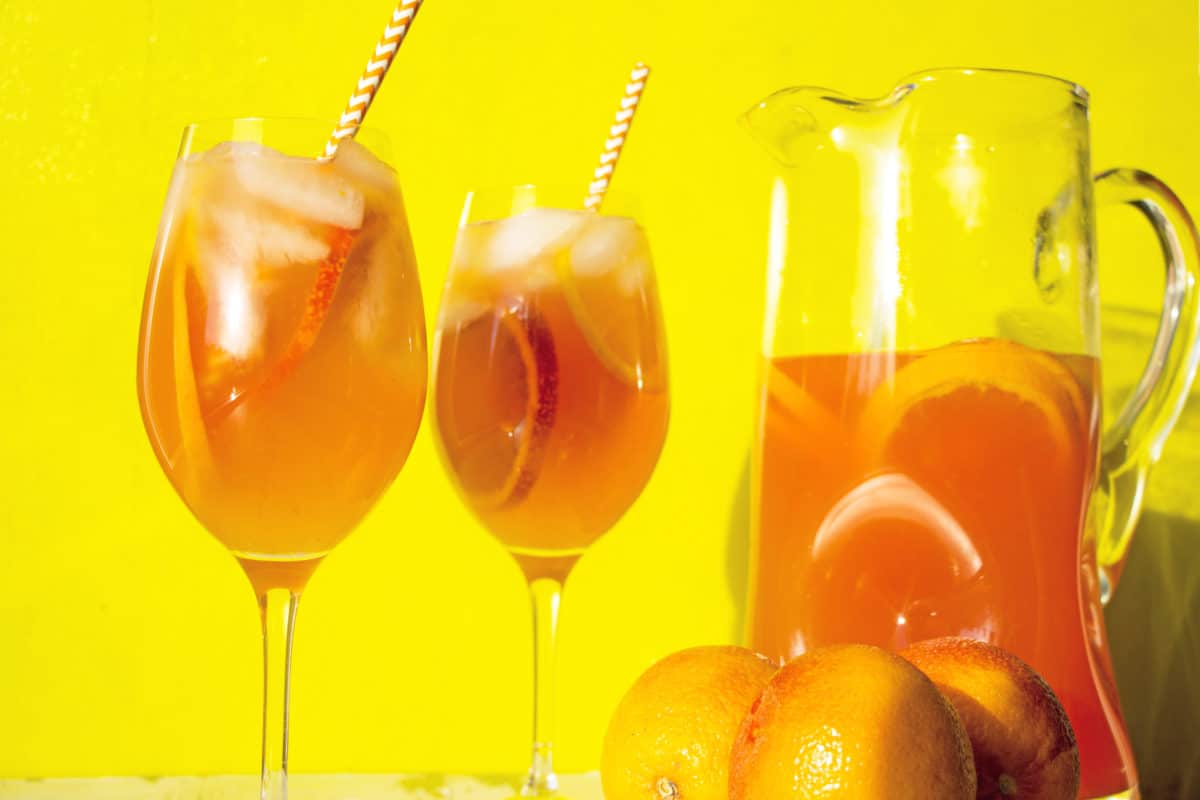 Orange White Wine Campari Sangria in glasses and a pitcher.