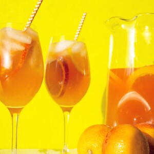 Orange White Wine Campari Sangria in glasses and a pitcher.