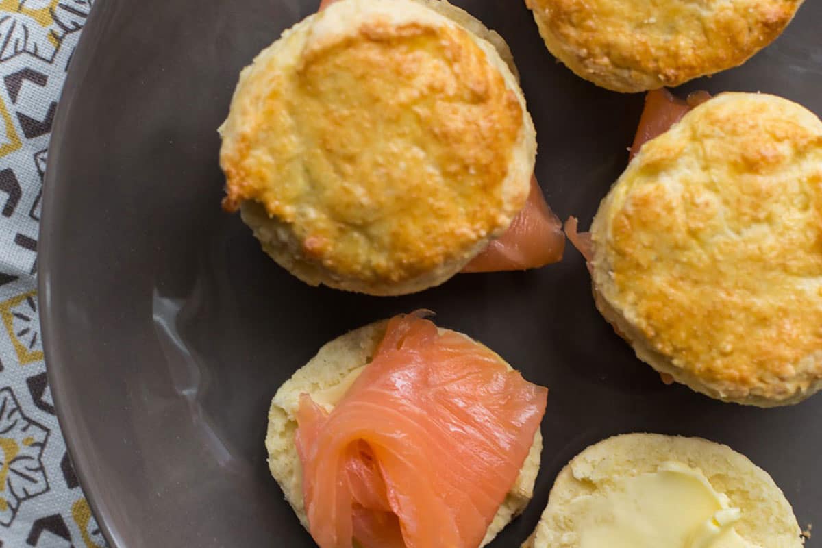 Irish scones topped with smoked salmon on grey plate.