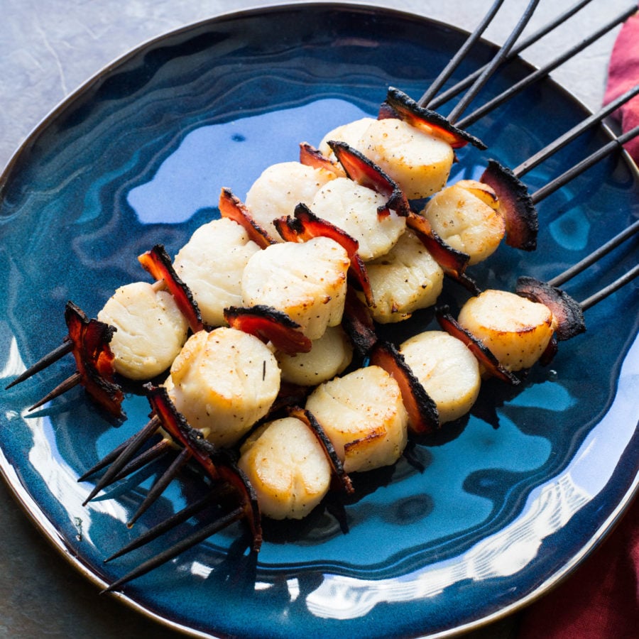 Scallop and Pancetta Kebabs with Balsamic Glaze piled on a plate.