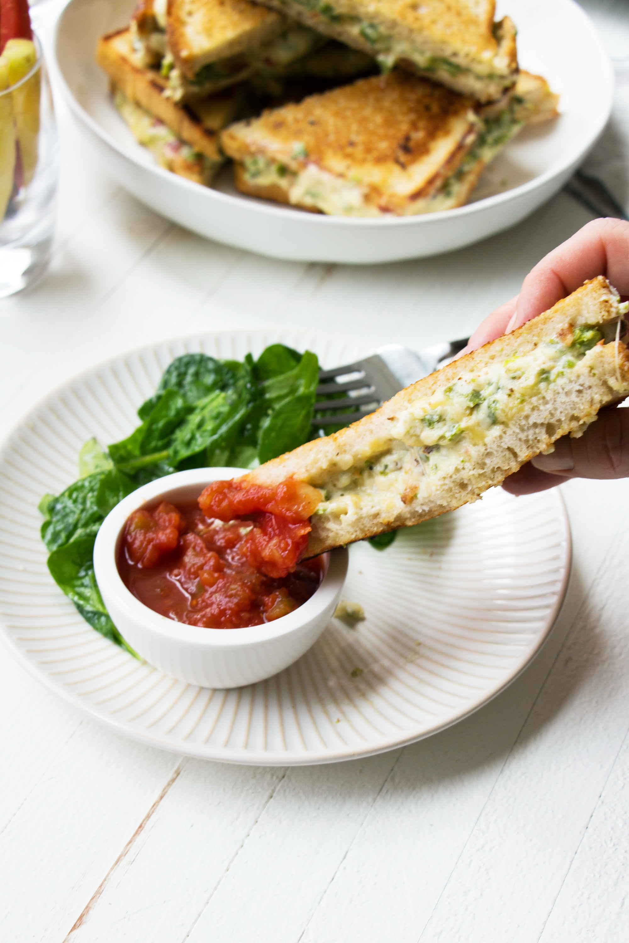 Jalapeno Popper Grilled Cheese sandwich dipping into salsa.