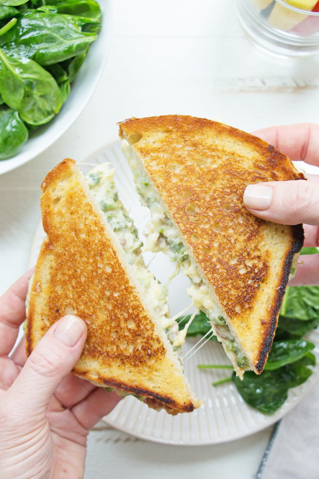Woman holding two slices of Jalapeno Popper Grilled Cheese .