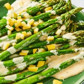 Green plate with Roasted Asparagus with Creamy Lemon DressingRoasted Asparagus and Creamy Lemon Dressing.