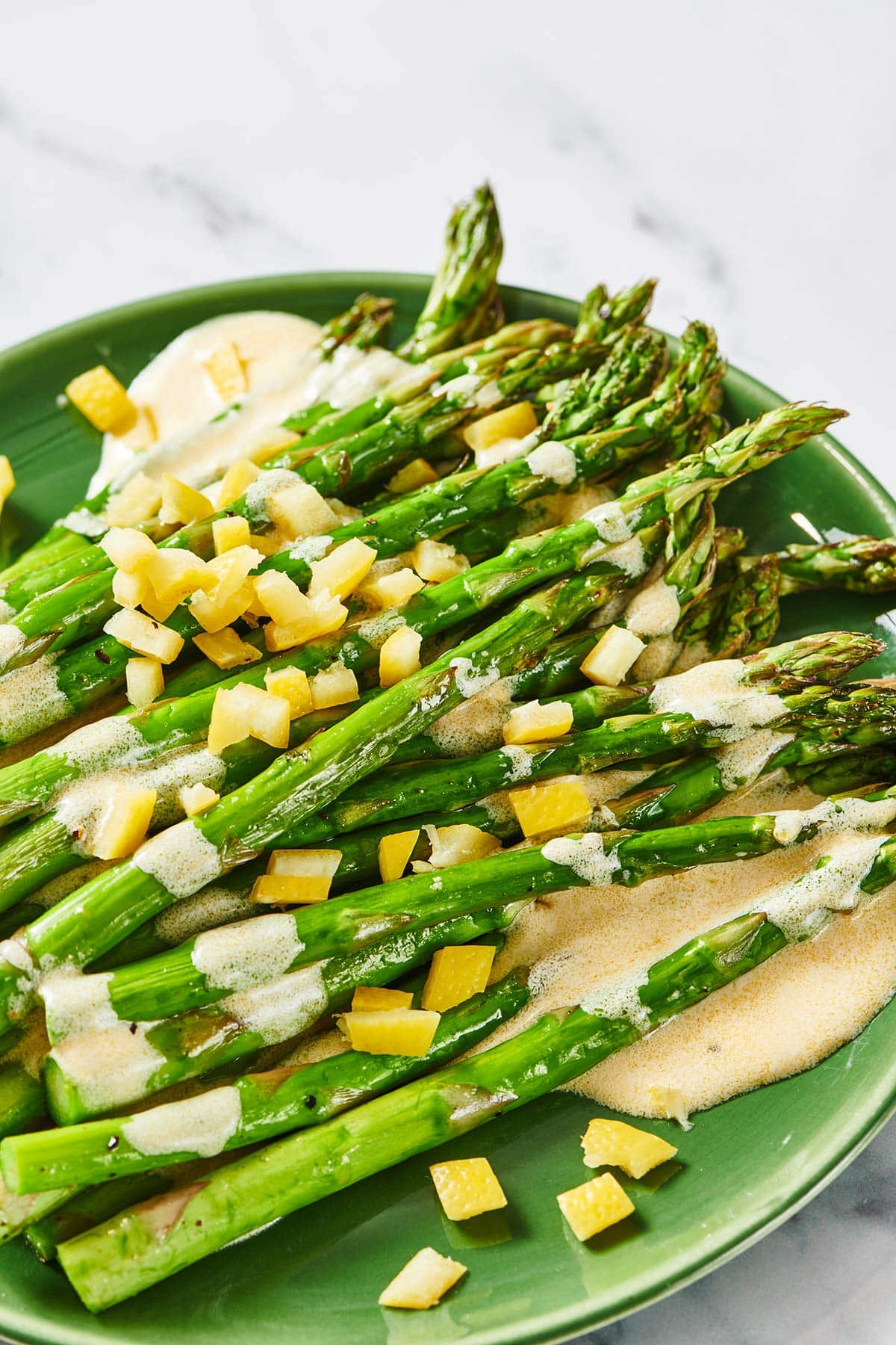 Plate of Roasted Asparagus topped with Creamy Lemon Dressing.