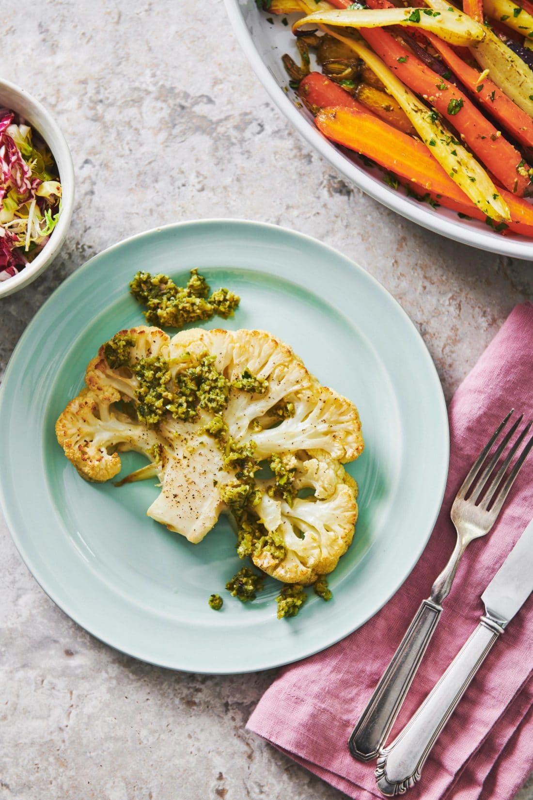 Plate with a Roasted Cauliflower Steak topped with Tapenade.