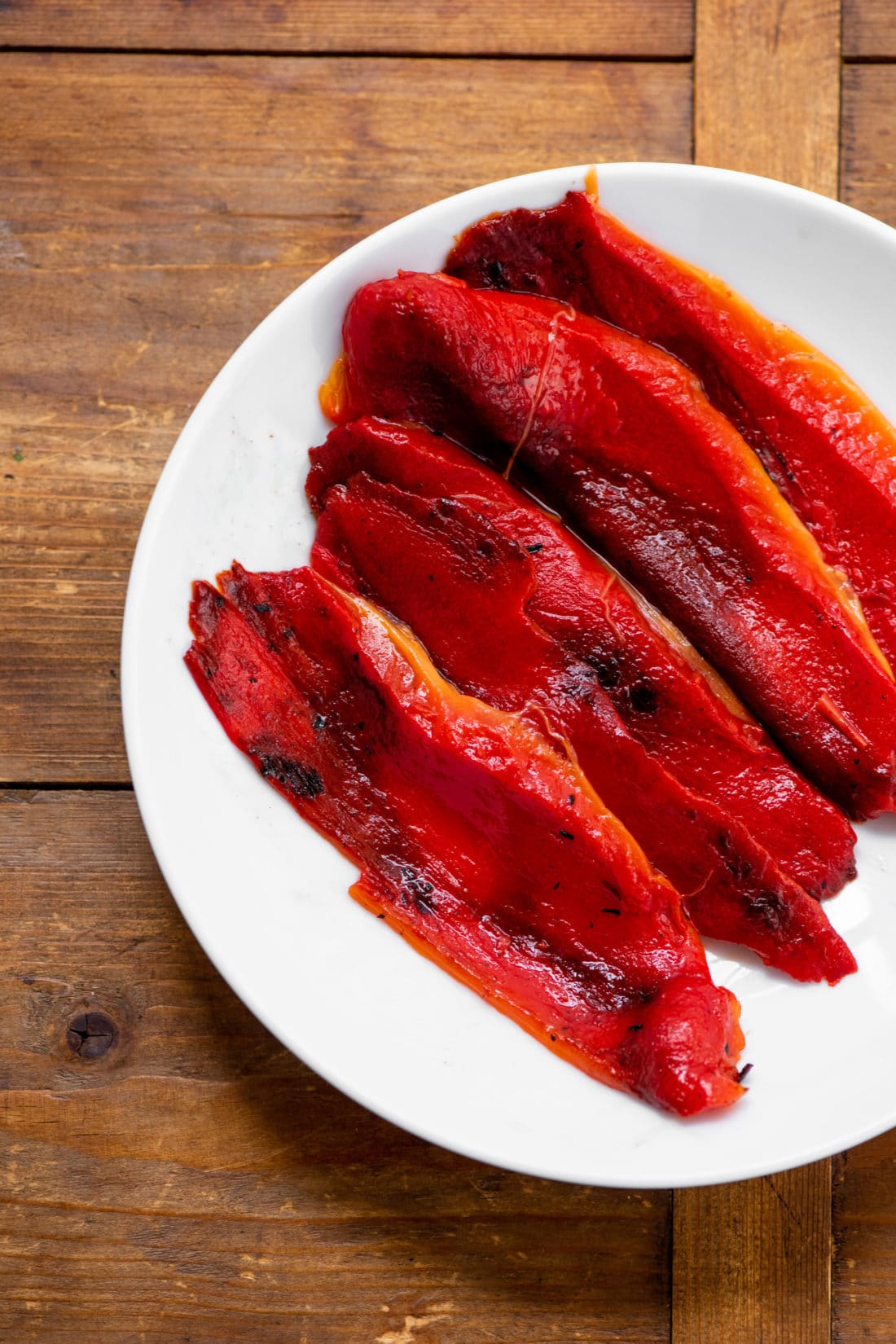 Roasted red peppers on a white plate.