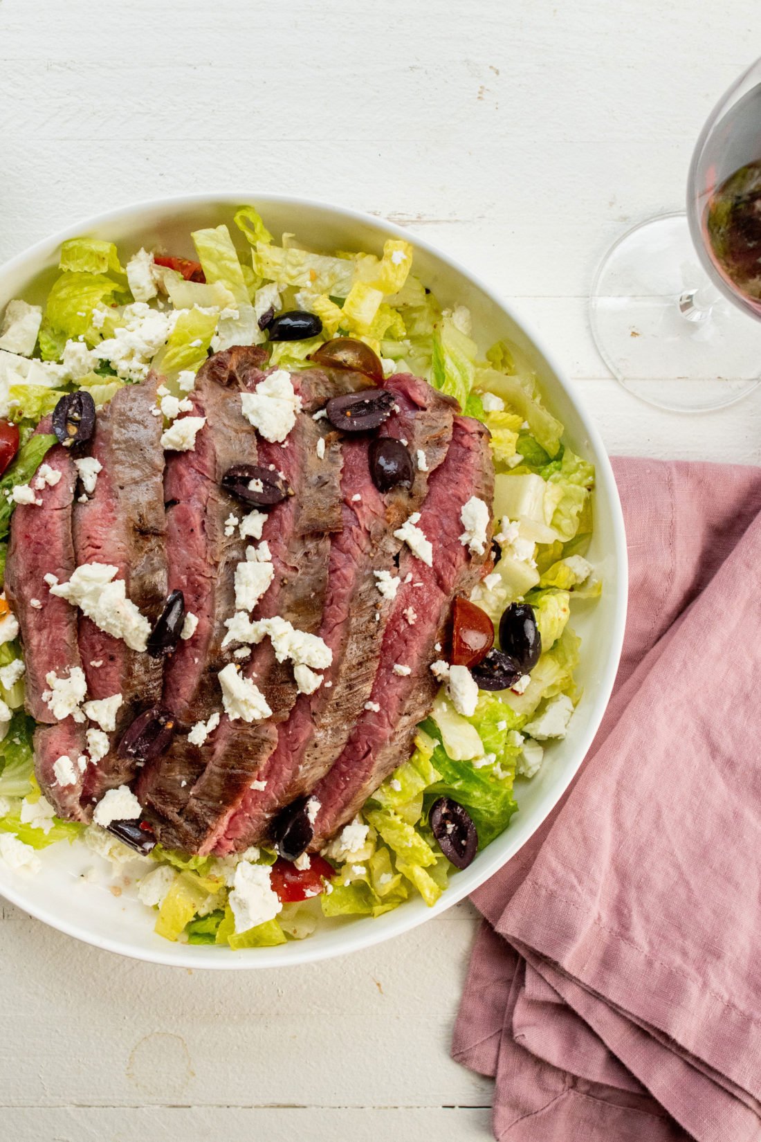 Olives and feta atop a Greek Salad with Flank Steak.