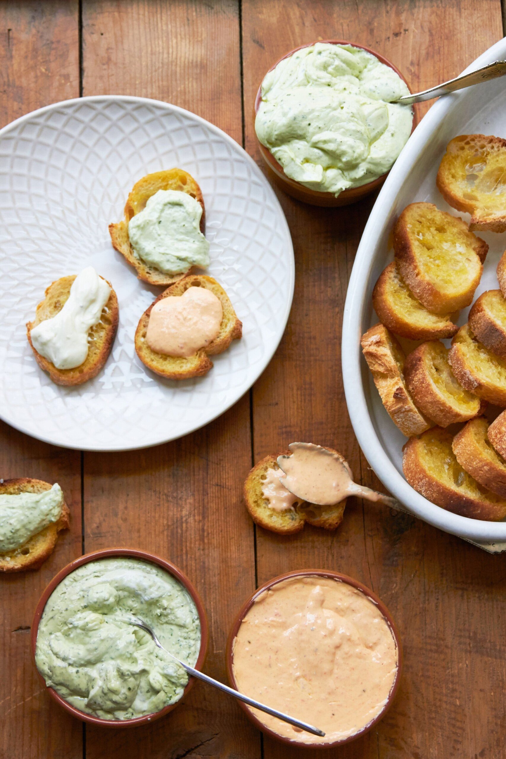 Whipped fresh ricotta, bread, and dishes on a wooden table.