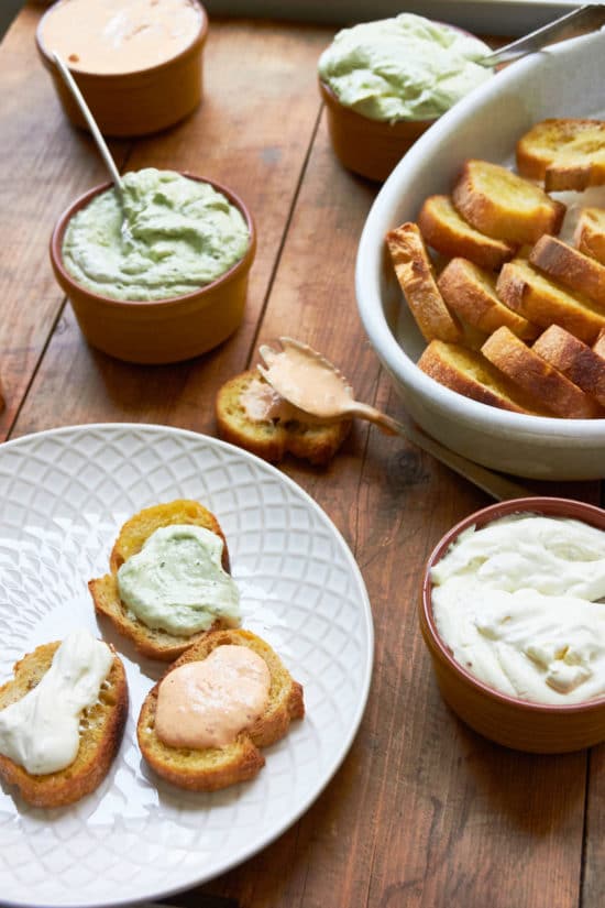 Plate with bread topped with different whipped fresh ricotta flavors.