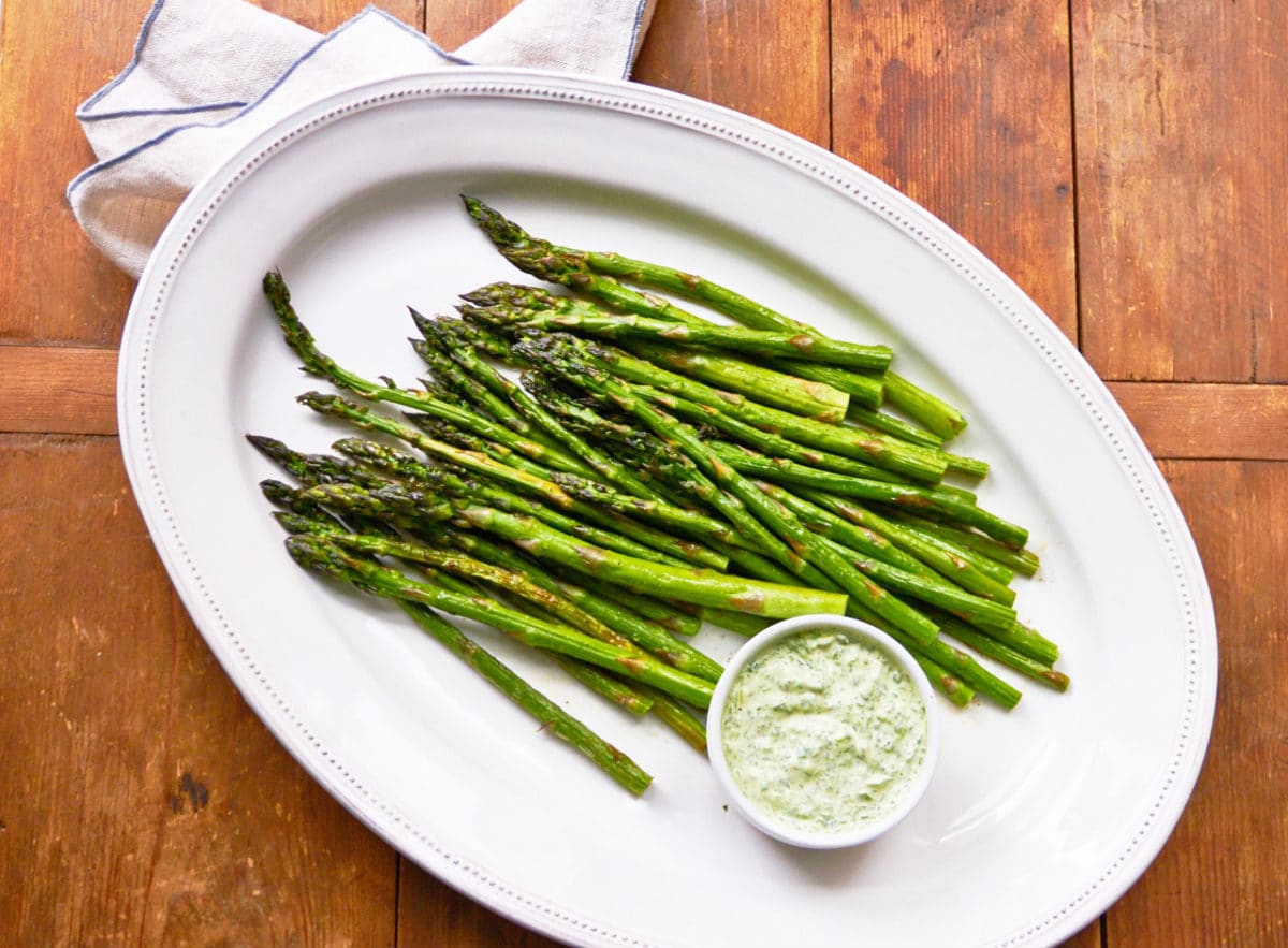 Asparagus with Herb Dipping Sauce on white plate.