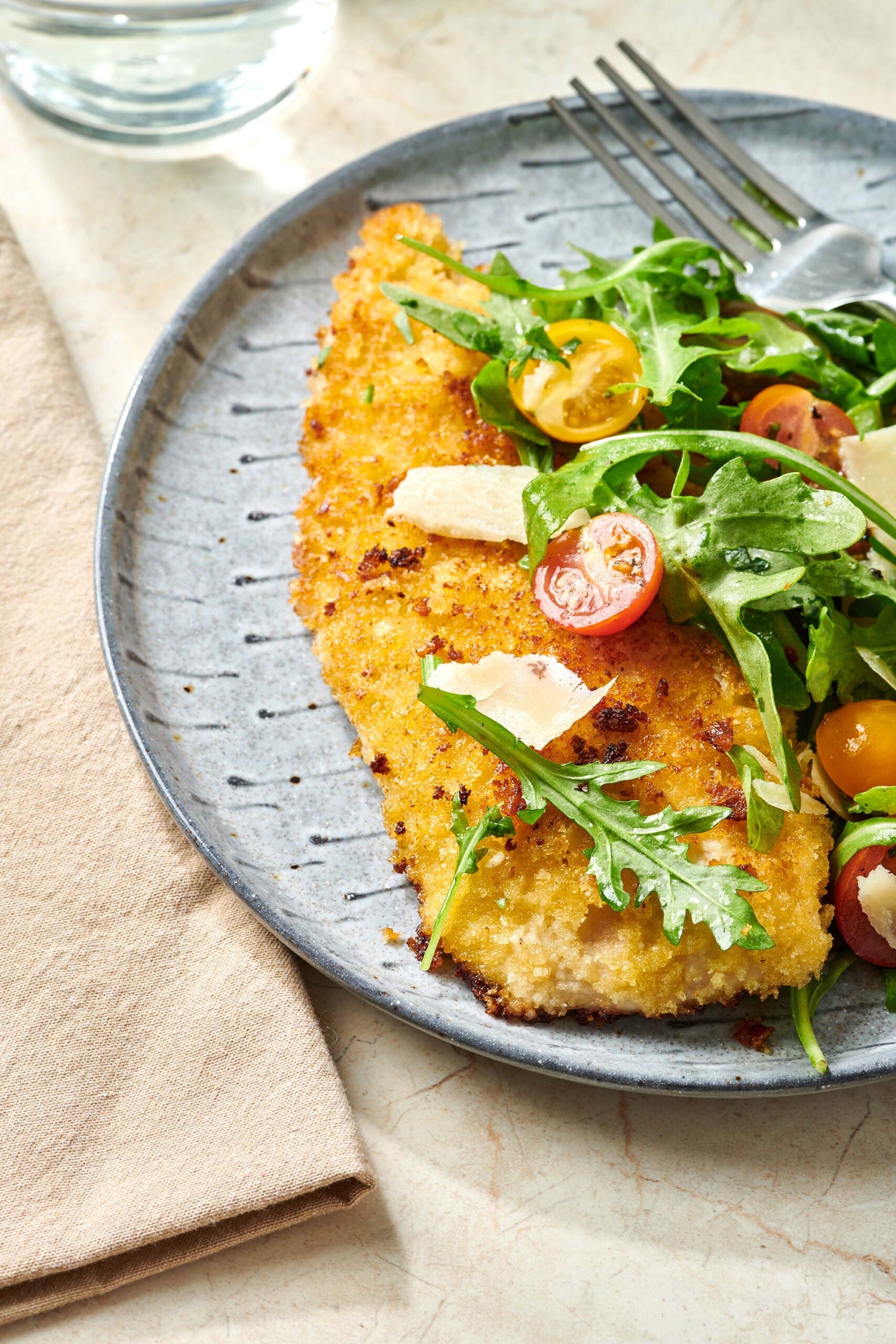 Chicken Milanese on plate with salad.