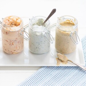 Glass jars with homemade pimento cheese spread, blue cheese, and roasted pepper dressing.