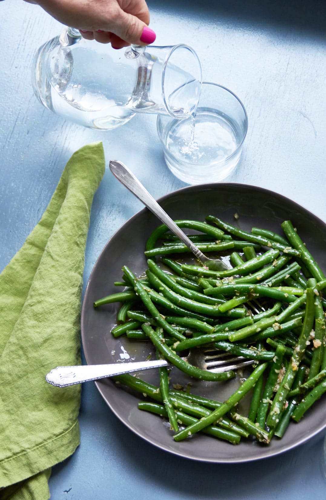 Two forks in a bowl of Green Beans with Tarragon Vinaigrette.