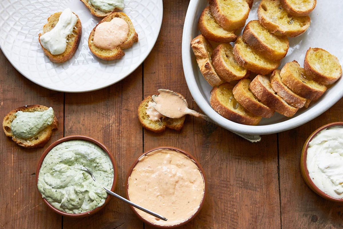 Wooden table with bread and whipped fresh ricotta.