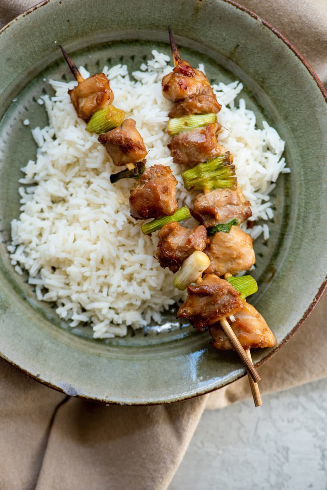 Chicken Yakitori skewers over rice.