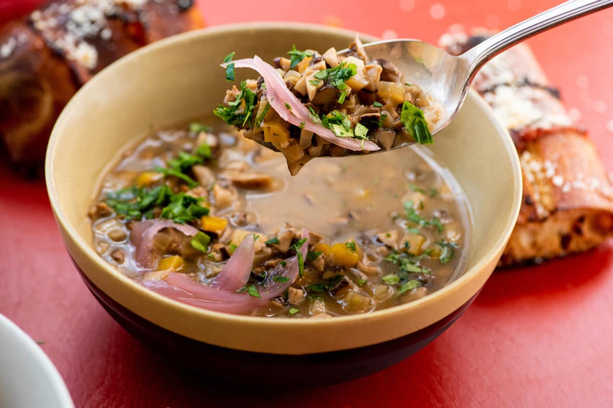 Spoon scooping Mushroom Spelt Soup from a bowl.