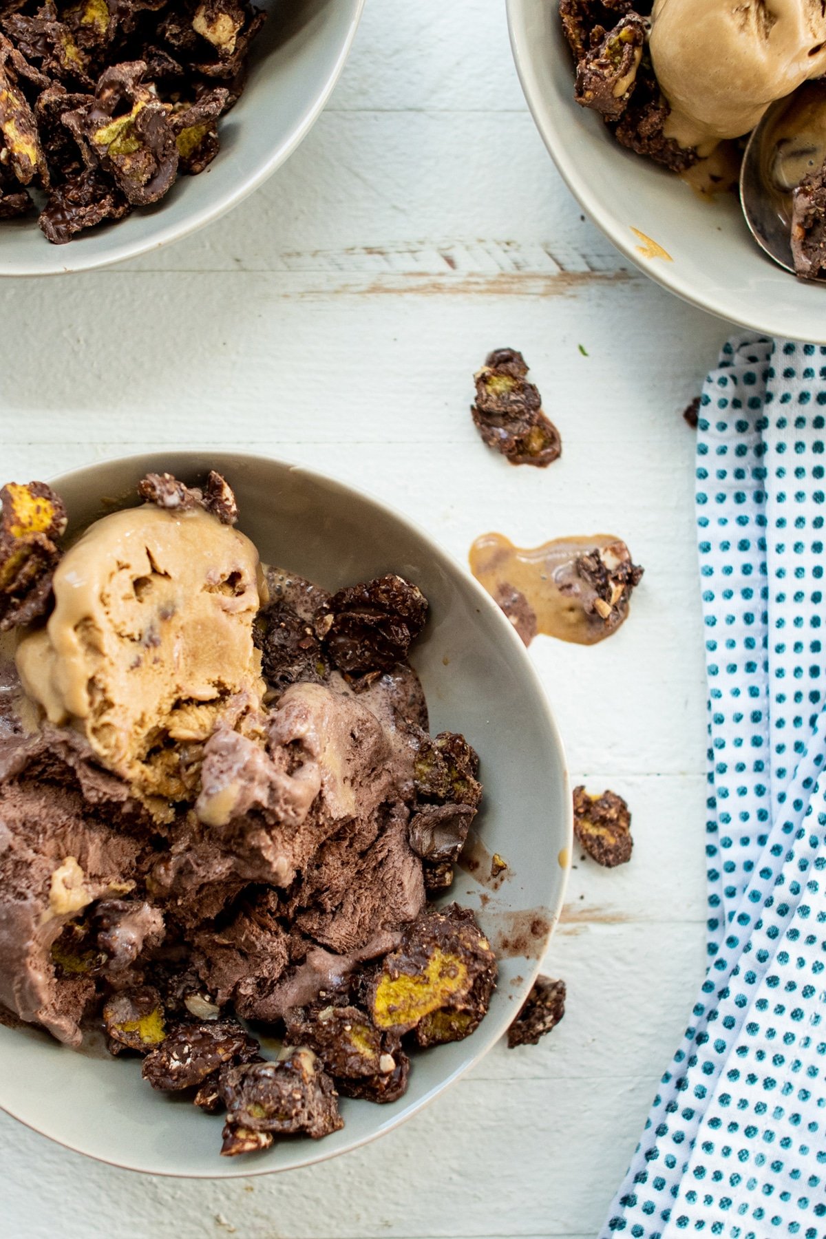 Chocolate Peanut Cornflake Crunch on top of ice cream in bowl.