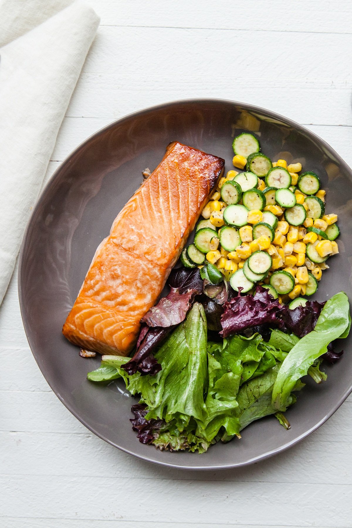 Simple Asian Salmon on plate with Sautéed Corn and Zucchini.