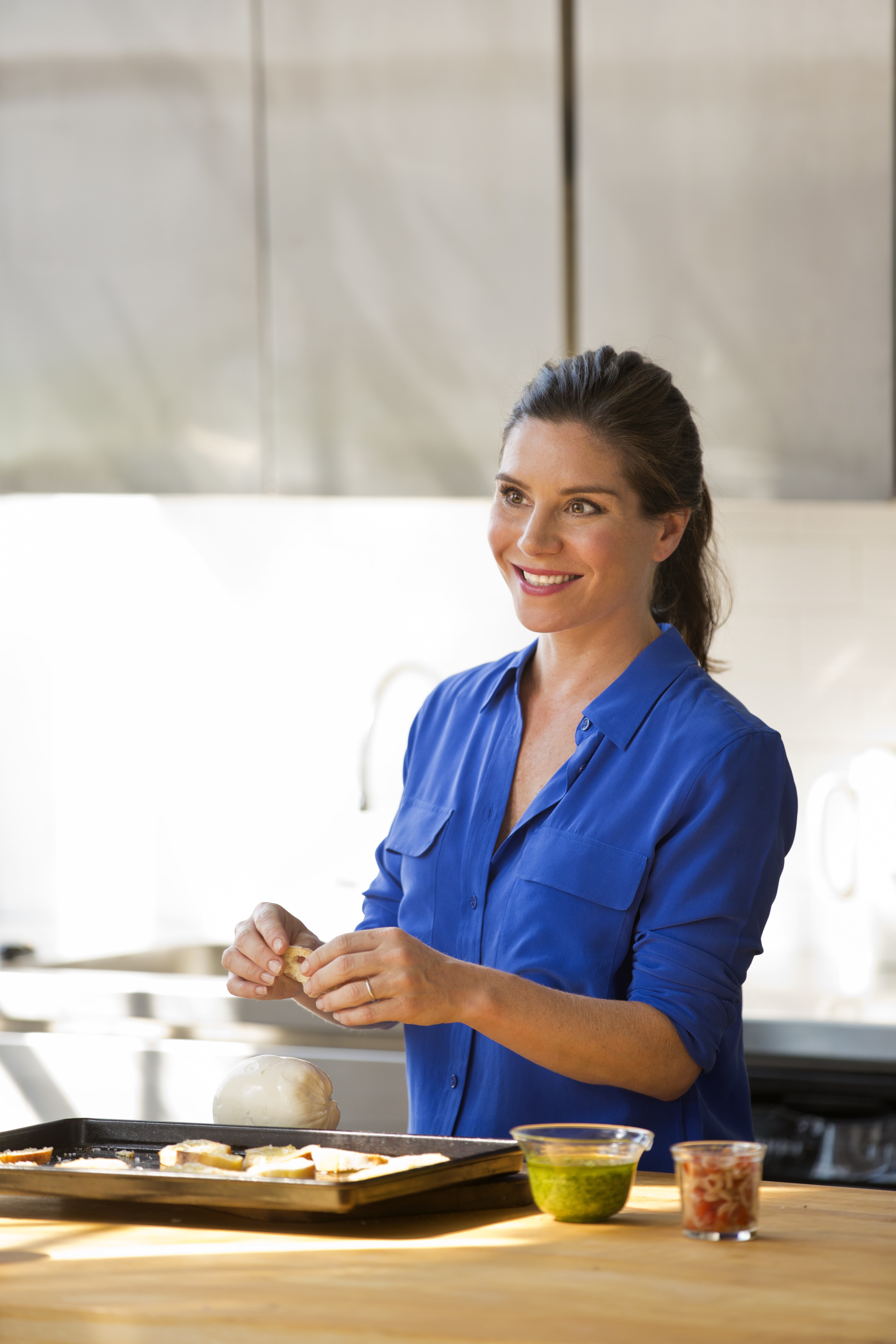 Katie Workman in a blue shirt standing at a counter.