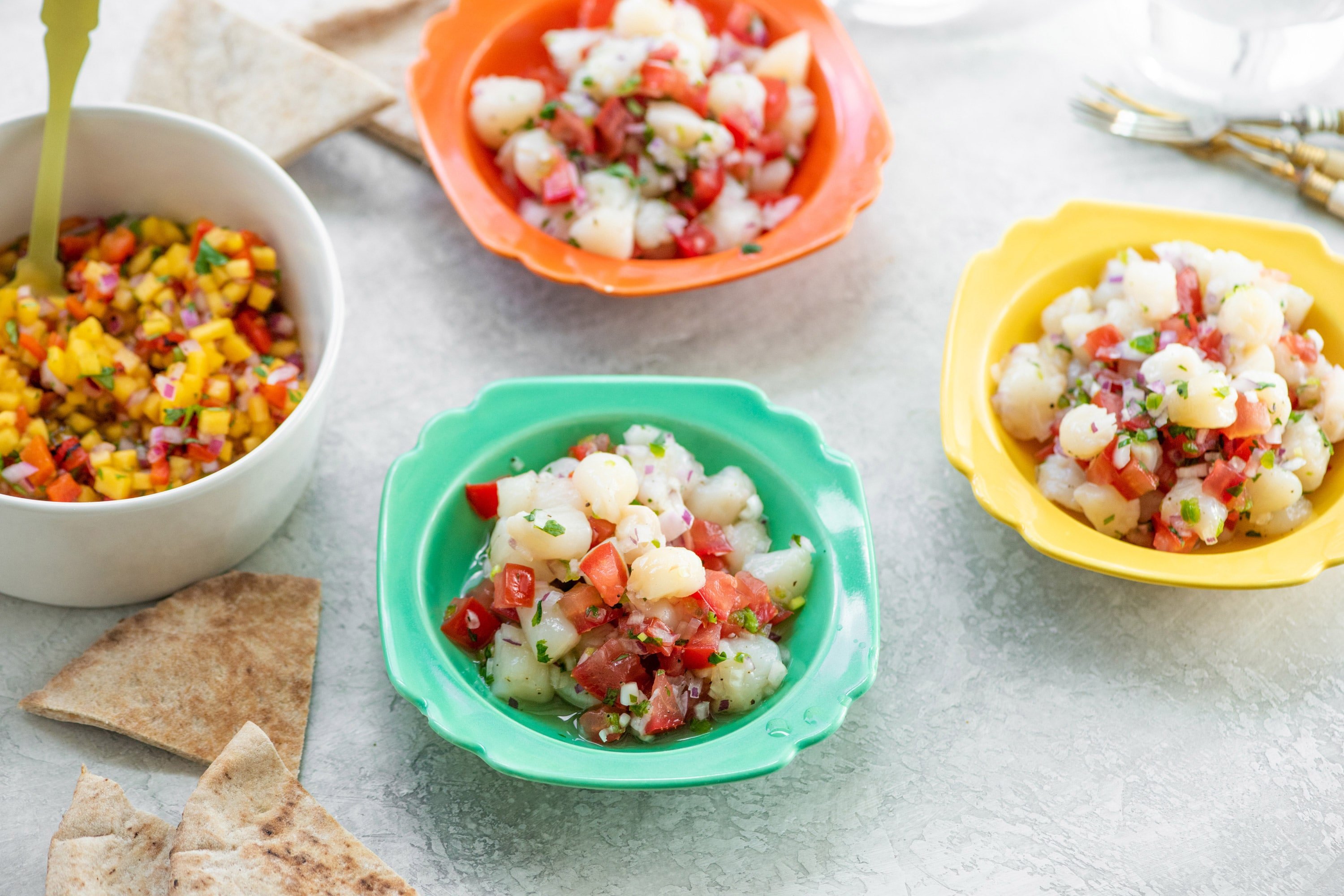 Little bowls of scallop ceviche with fruit salsa in a serving bowl.