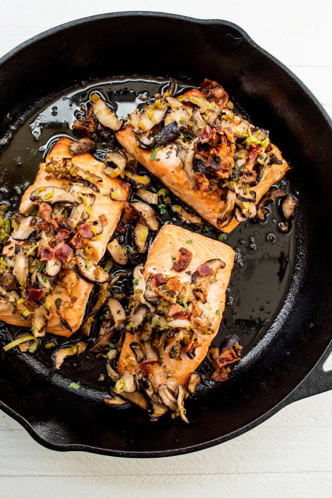 Orange Salmon with Leeks and Mushrooms in a skillet.