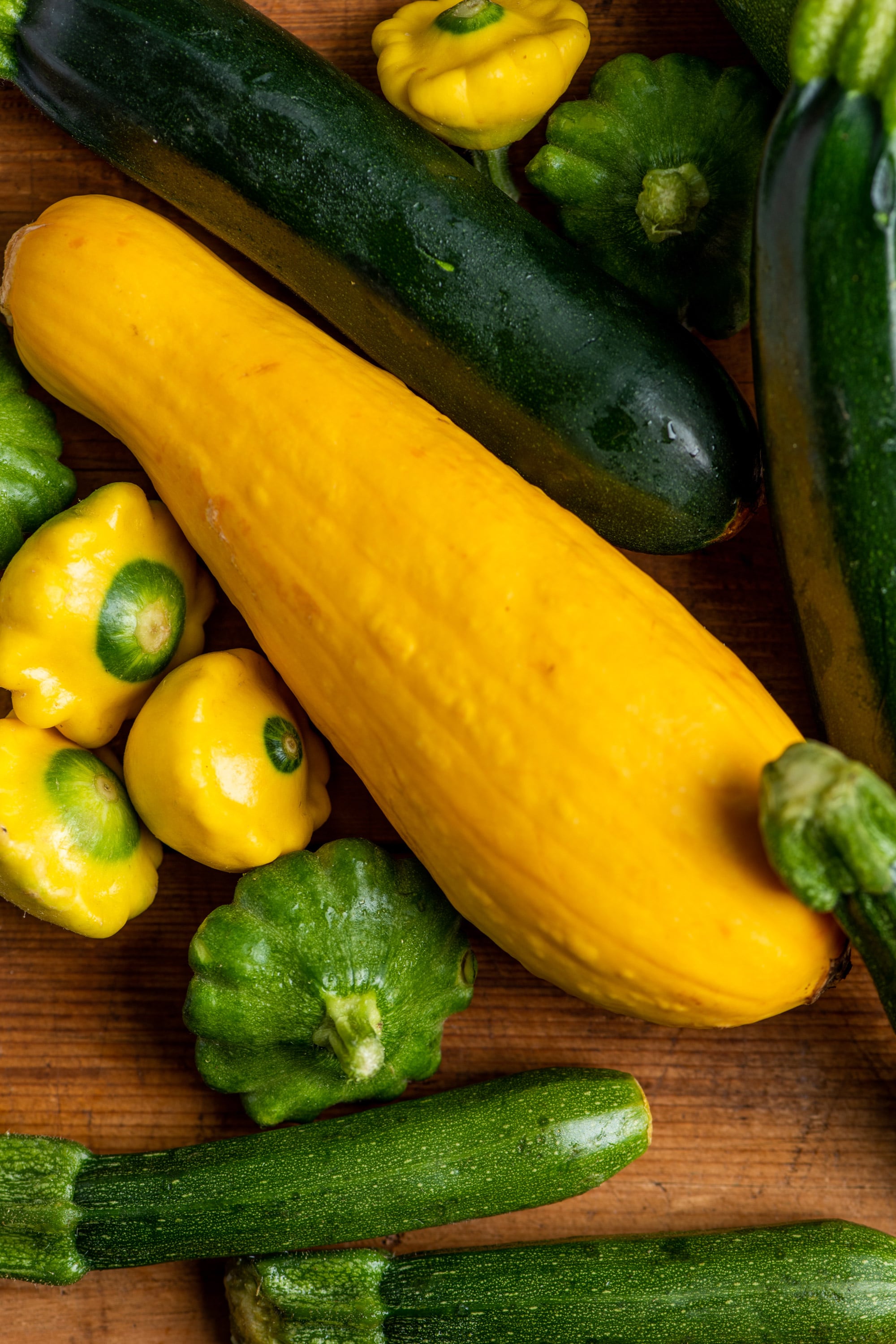 Fresh summer squash and zucchini of various sizes.