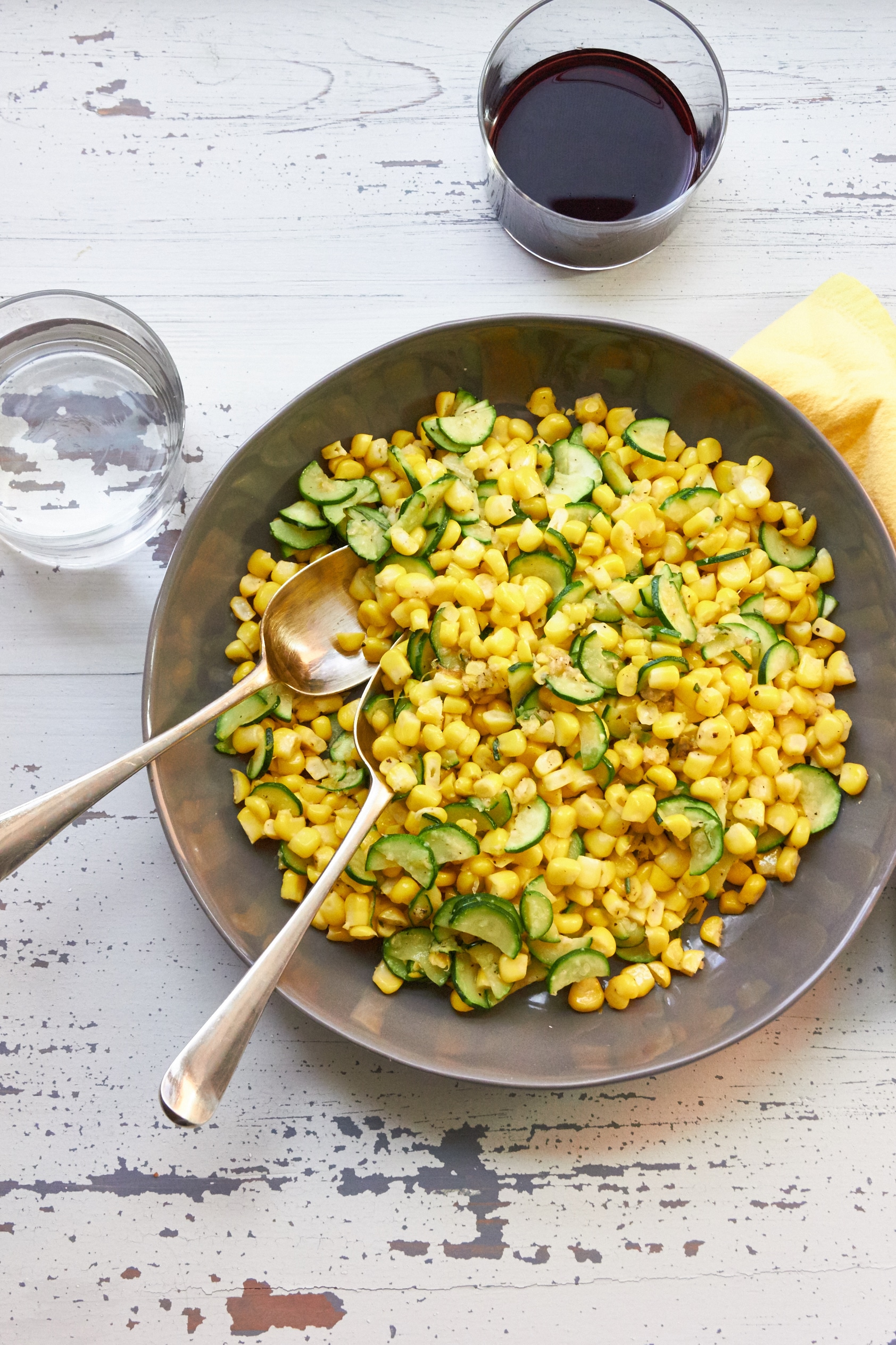 Sautéed Corn and Zucchini in Lemony Browned Butter piled in serving bowl with spoons.