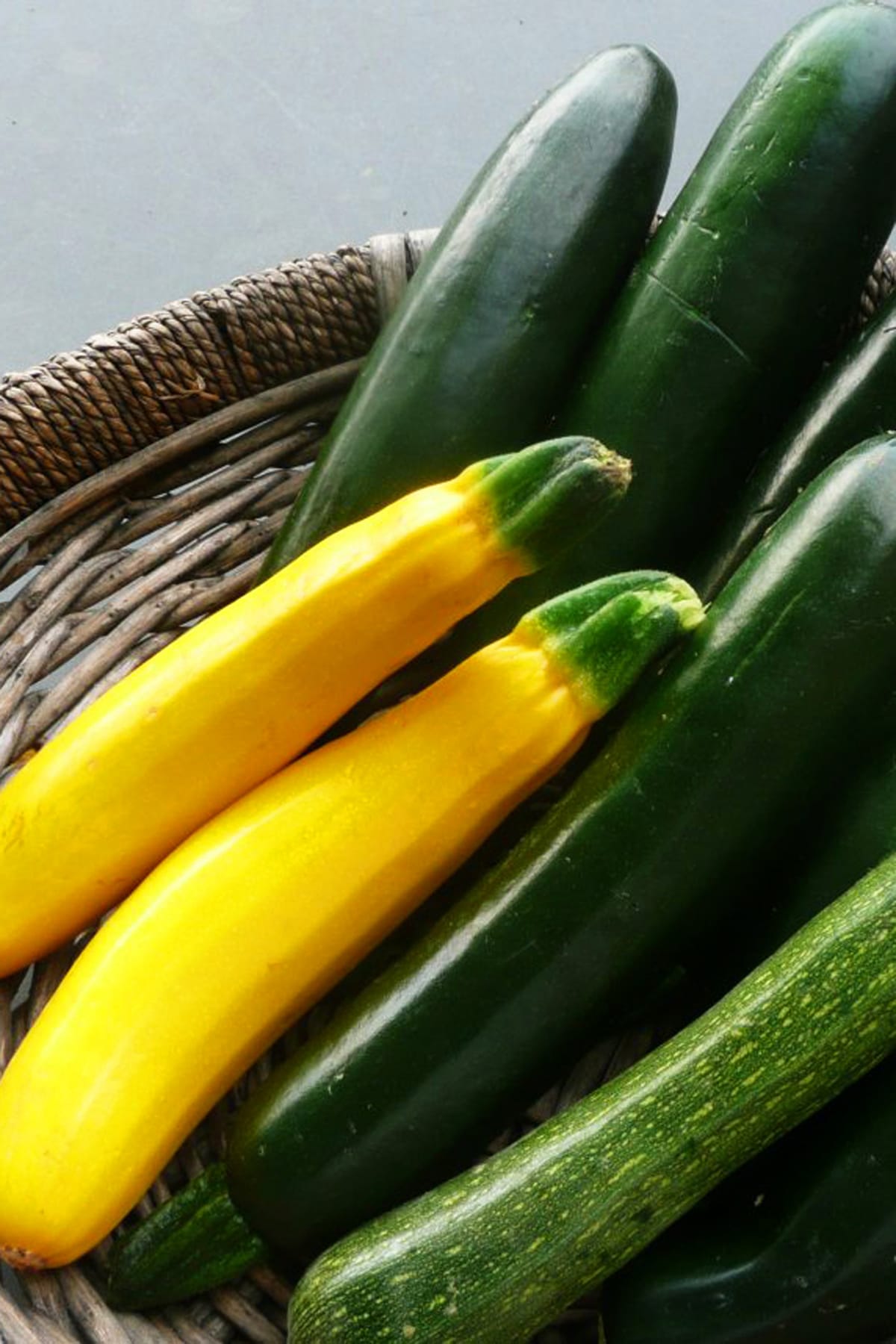 Fresh zucchini and yellow summer squash in basket.