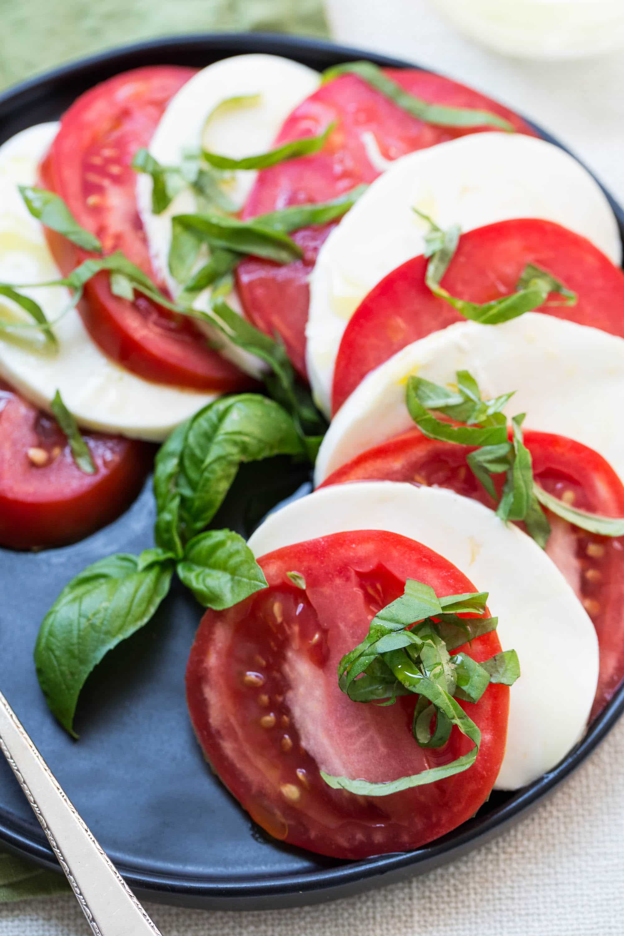 Tomato and Mozzarella Caprese Salad on a black plate.