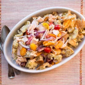 Salmon Panzanella in white serving dish on table.