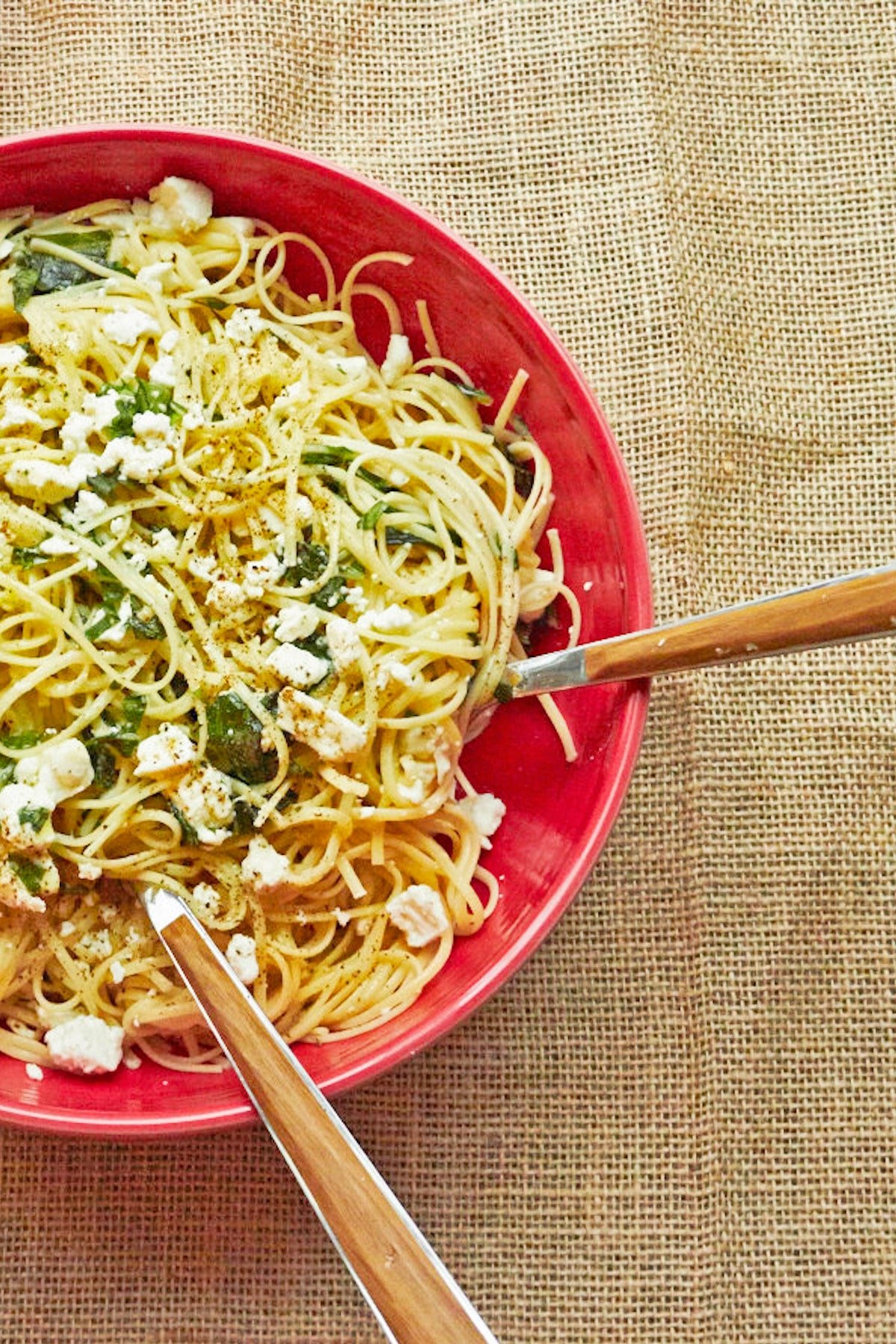 Linguine with Lemon, Feta and Basil in red bowl on burlap-covered table.