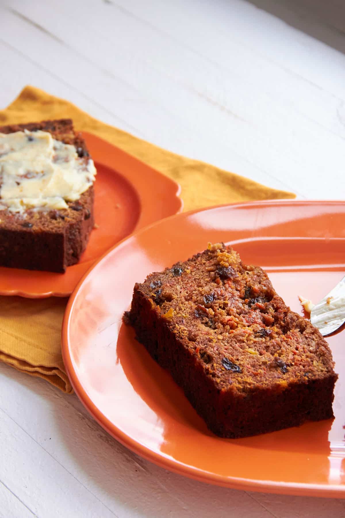Carrot Raisin Bread slices on orange plates.