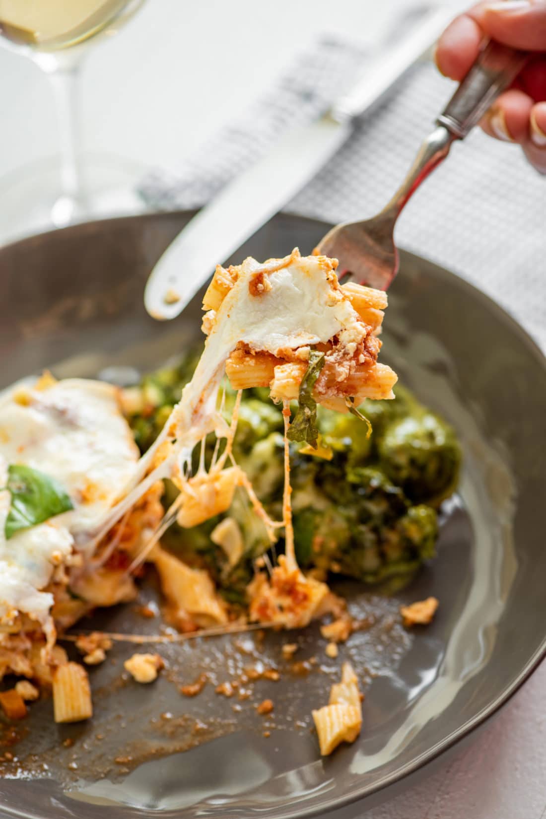 Fork grabbing some Ziti “Lasagna” with Bolognese Sauce from a plate.