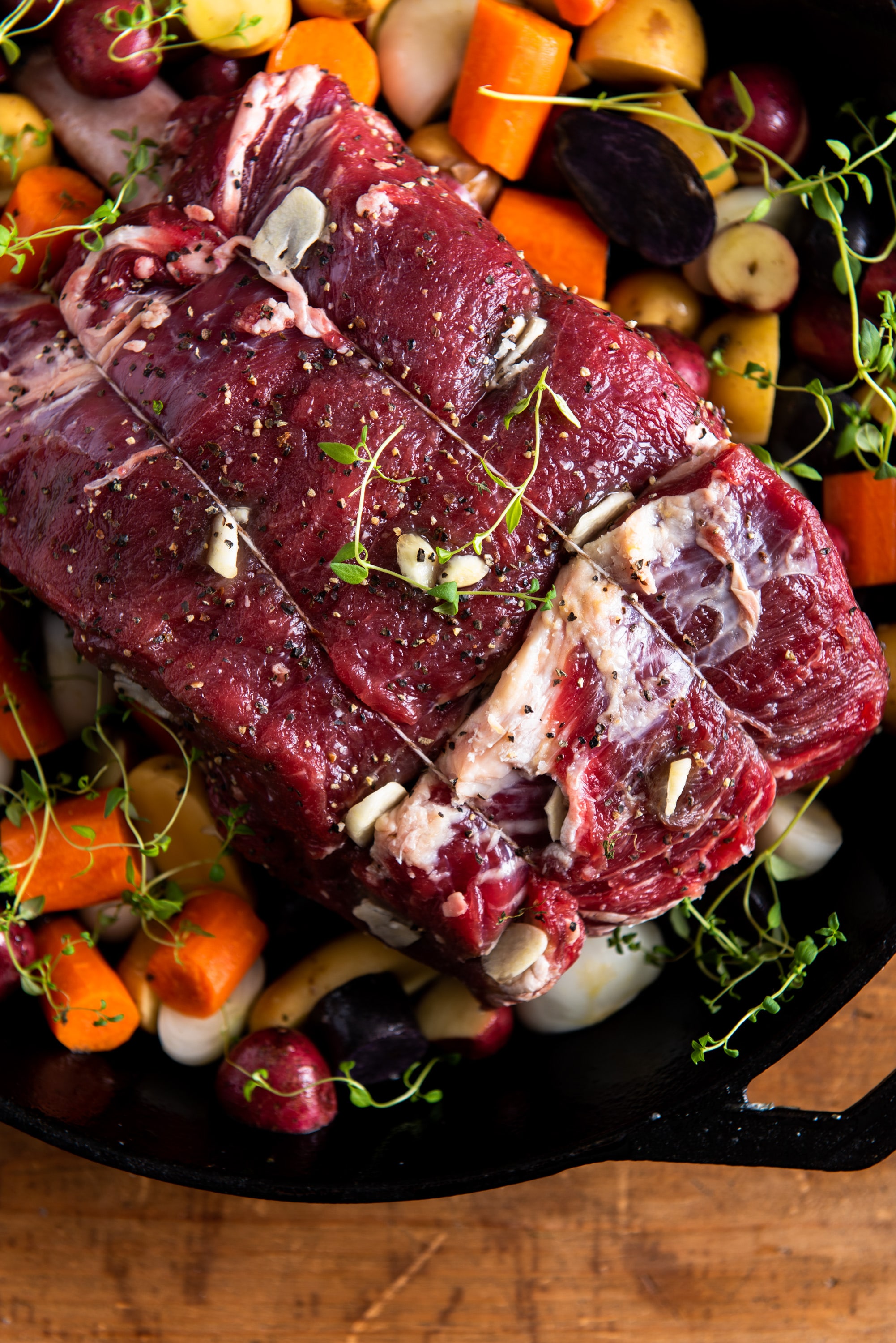 Uncooked standing rib roast with vegetables.
