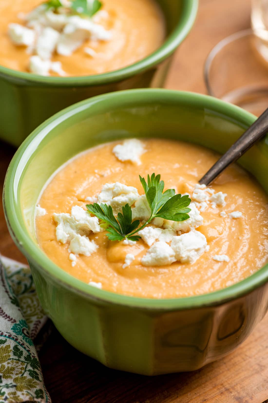 Spoon in a green bowl of Creamy Rutabaga, Carrot and Parsnip Soup.