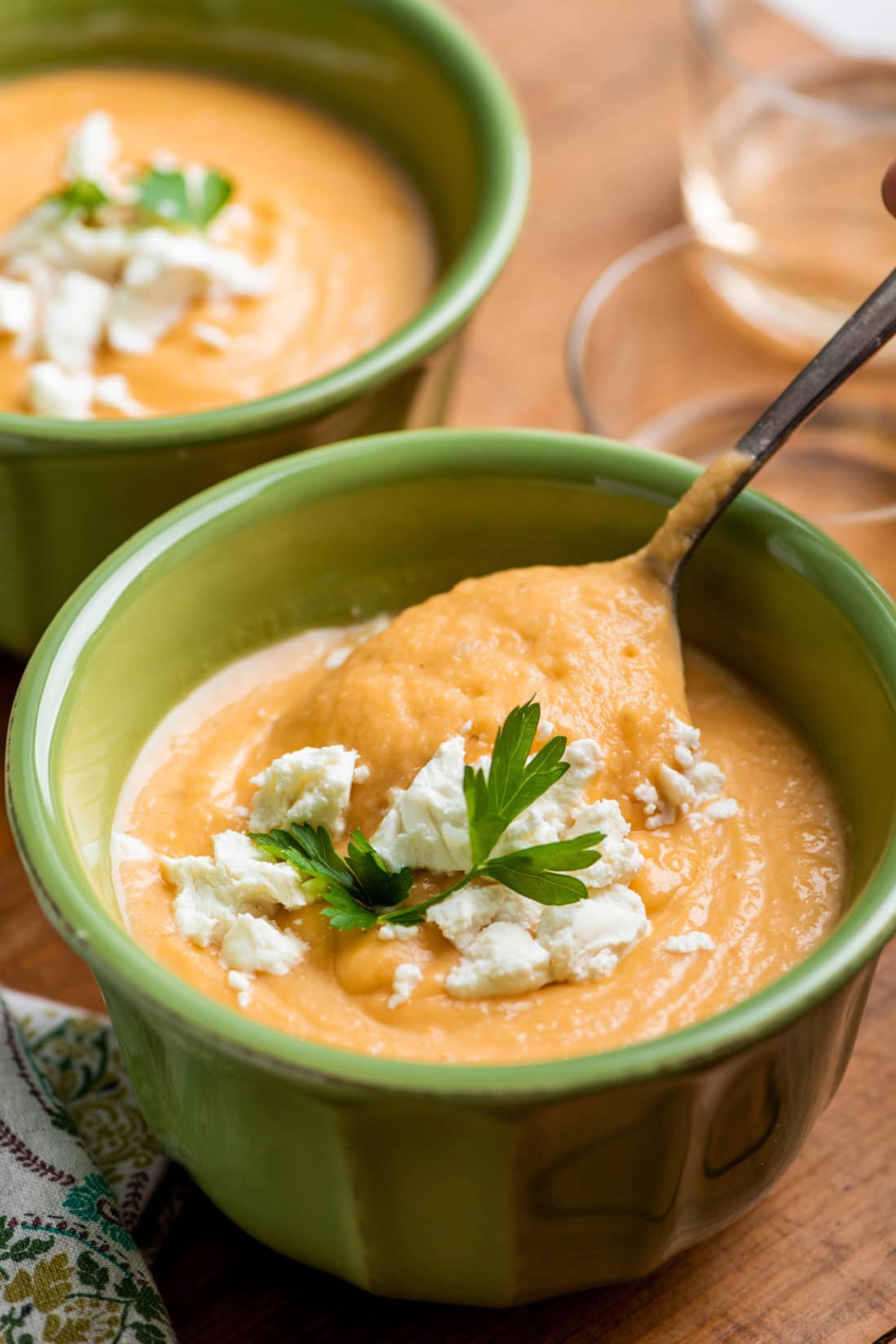 Spoon scooping Creamy Rutabaga, Carrot and Parsnip Soup from a bowl.