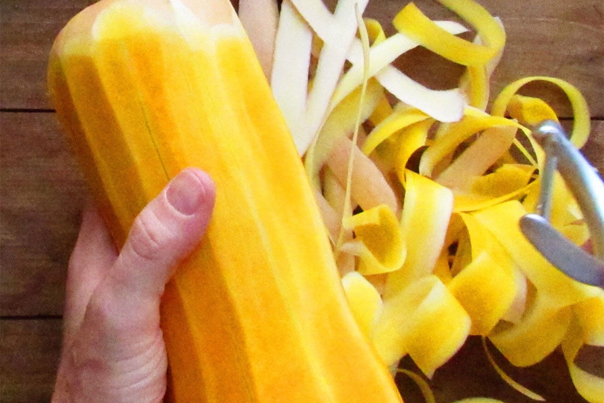 Woman peeling butternut squash.