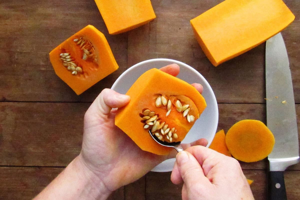 Scooping out seeds of butternut squash