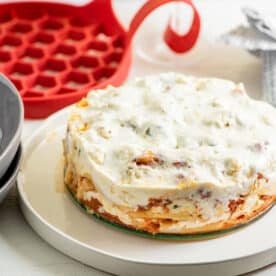 Baked ziti on plate near bowls and Instant Pot sling.