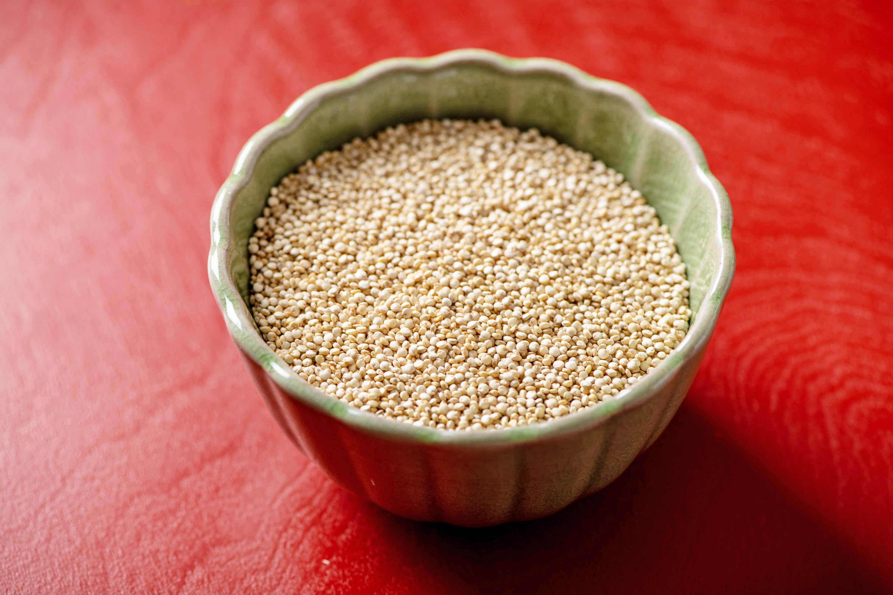 uncooked quinoa in a small green bowl