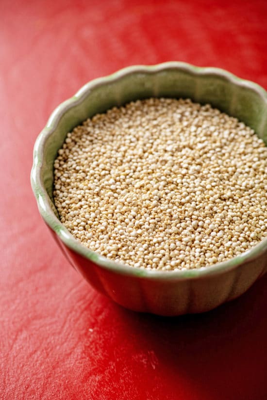 Small bowl of Quinoa on a red table.