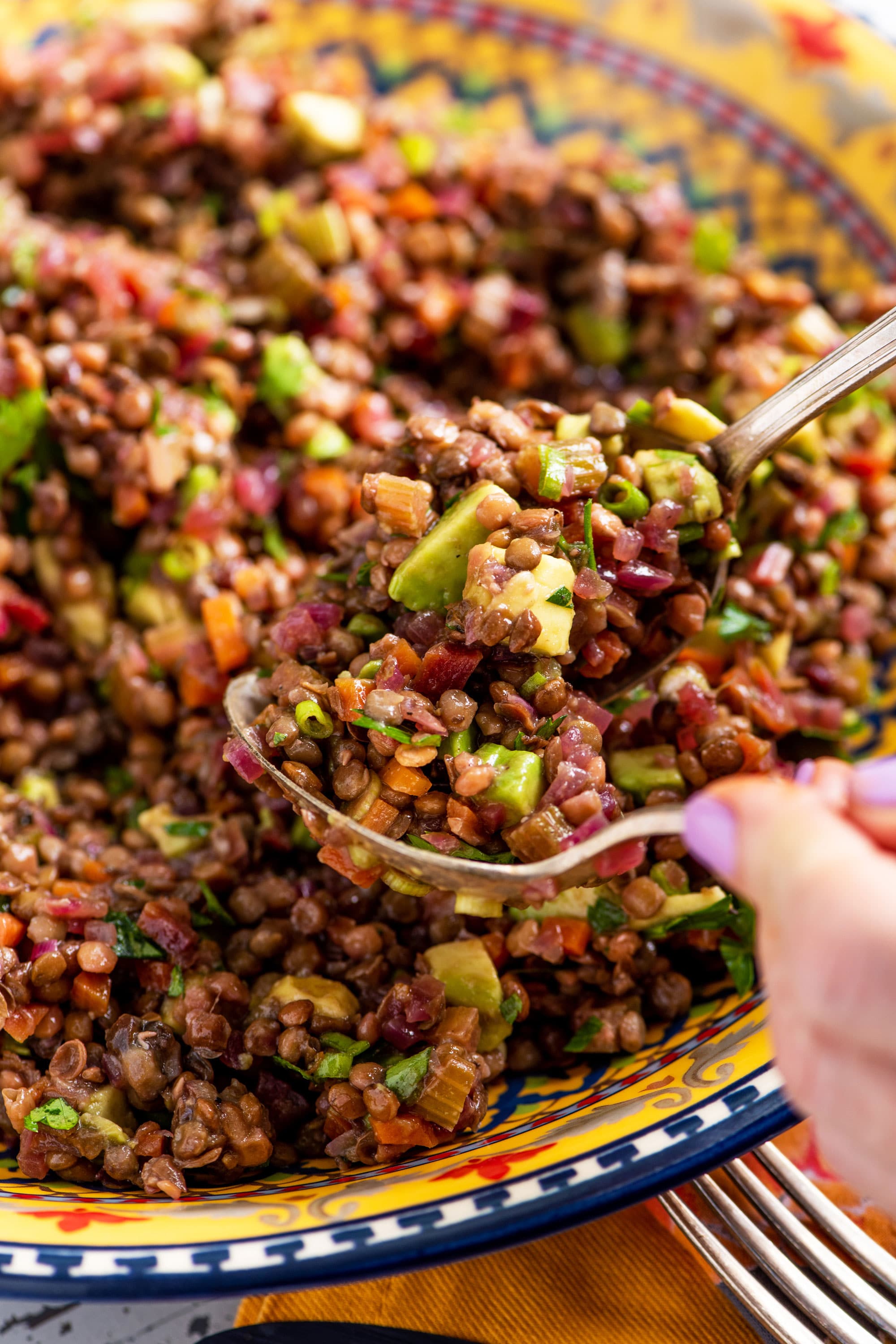Spoons scooping Lentil, Red Onion and Avocado Salad.