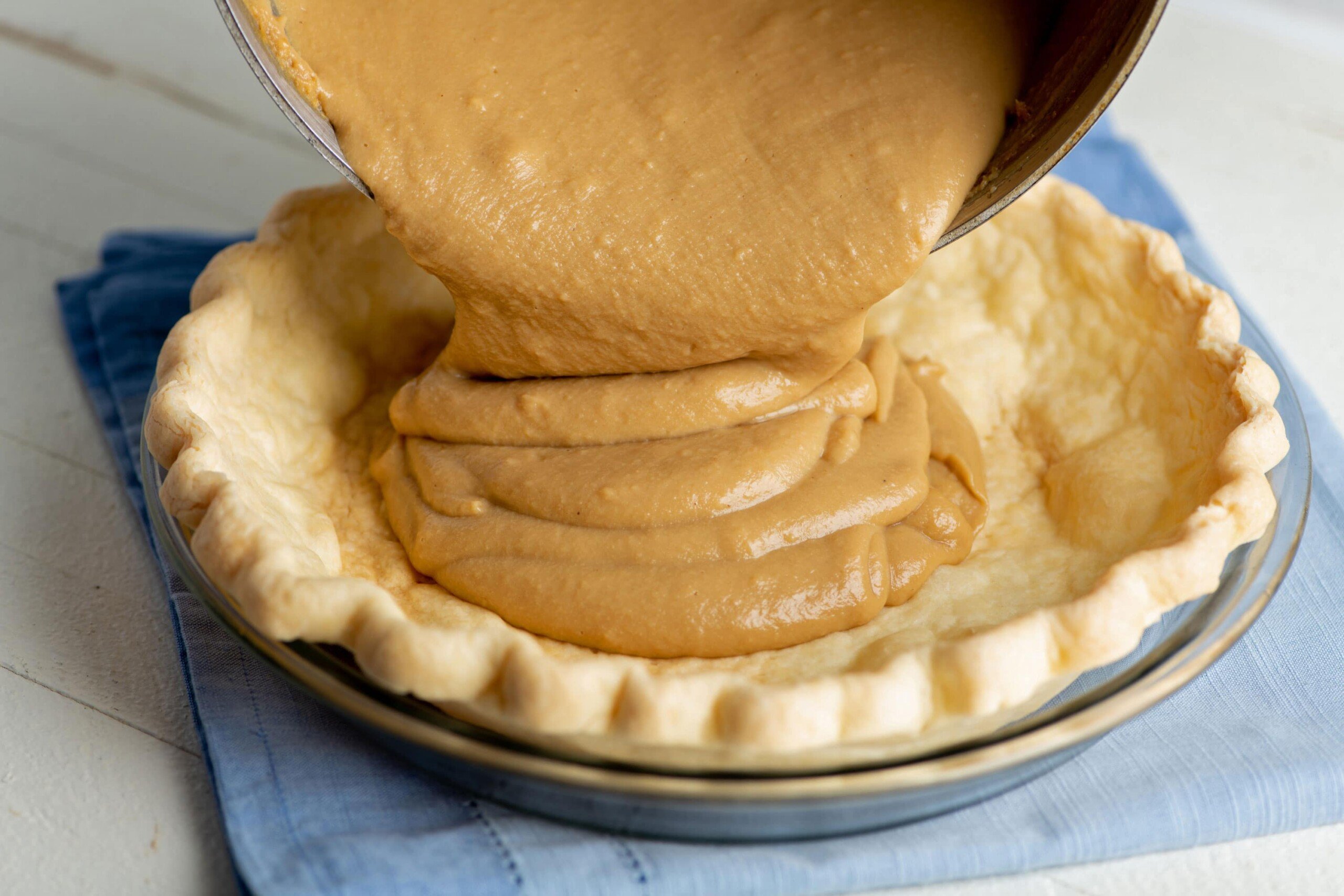 Butterscotch mixture pouring into a pie crust.