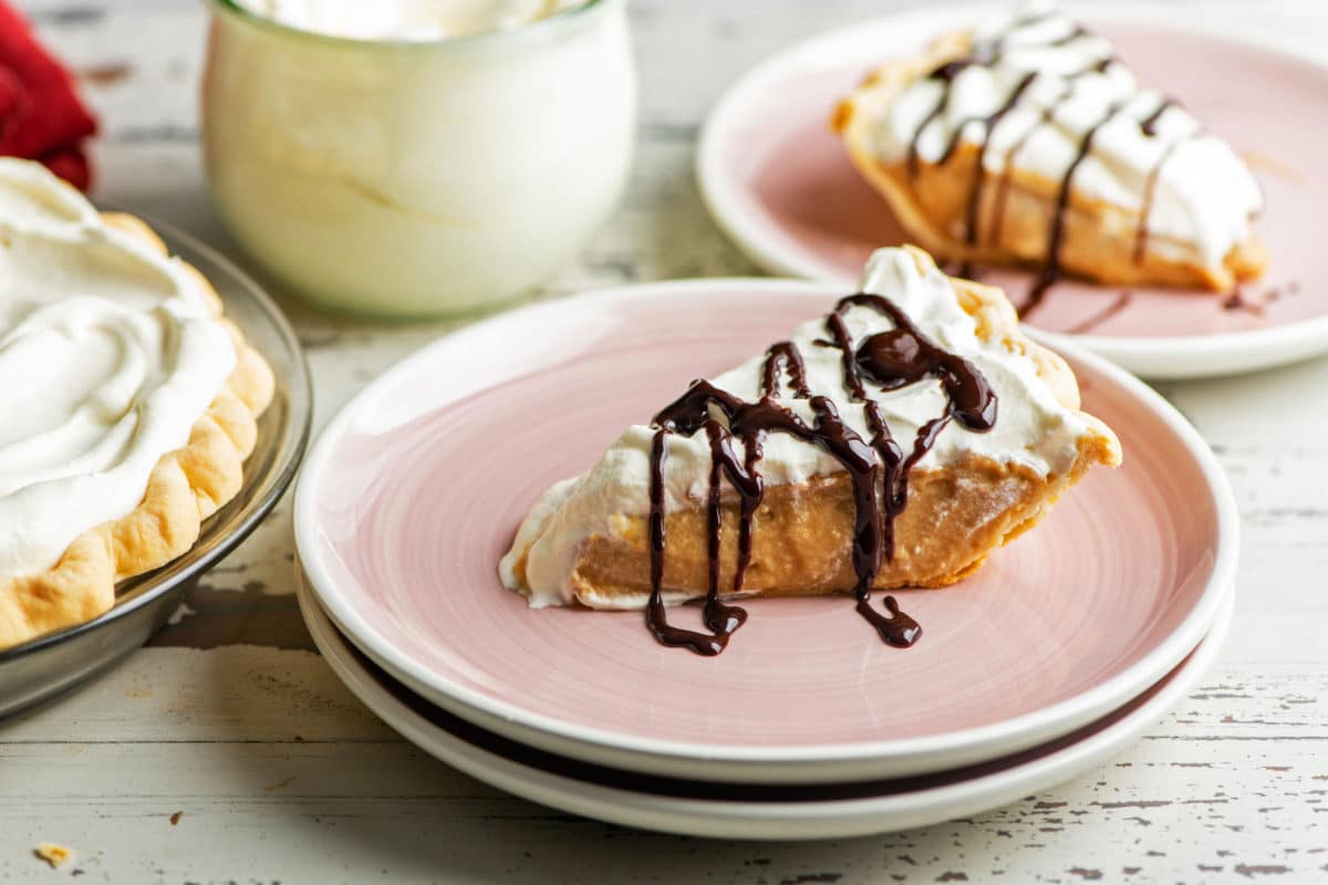 Slices of Salted Butterscotch Pie on pink plates.