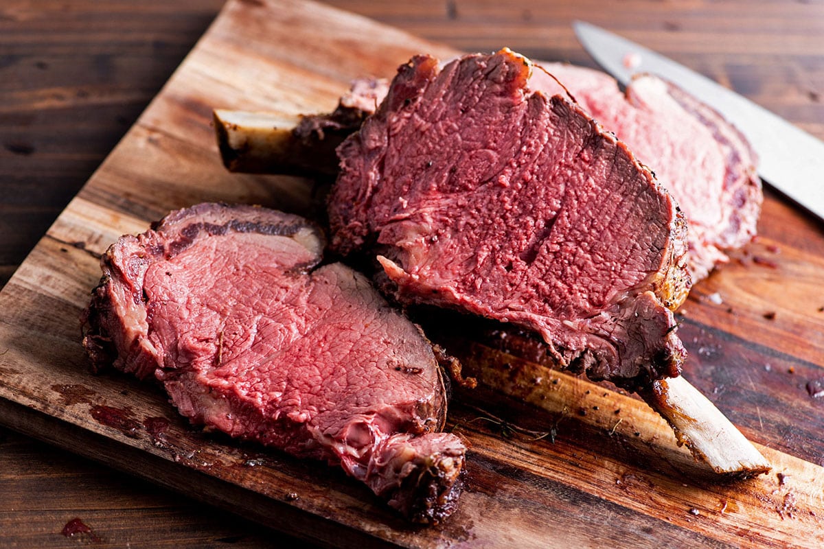Sliced prime rib roast on cutting board.