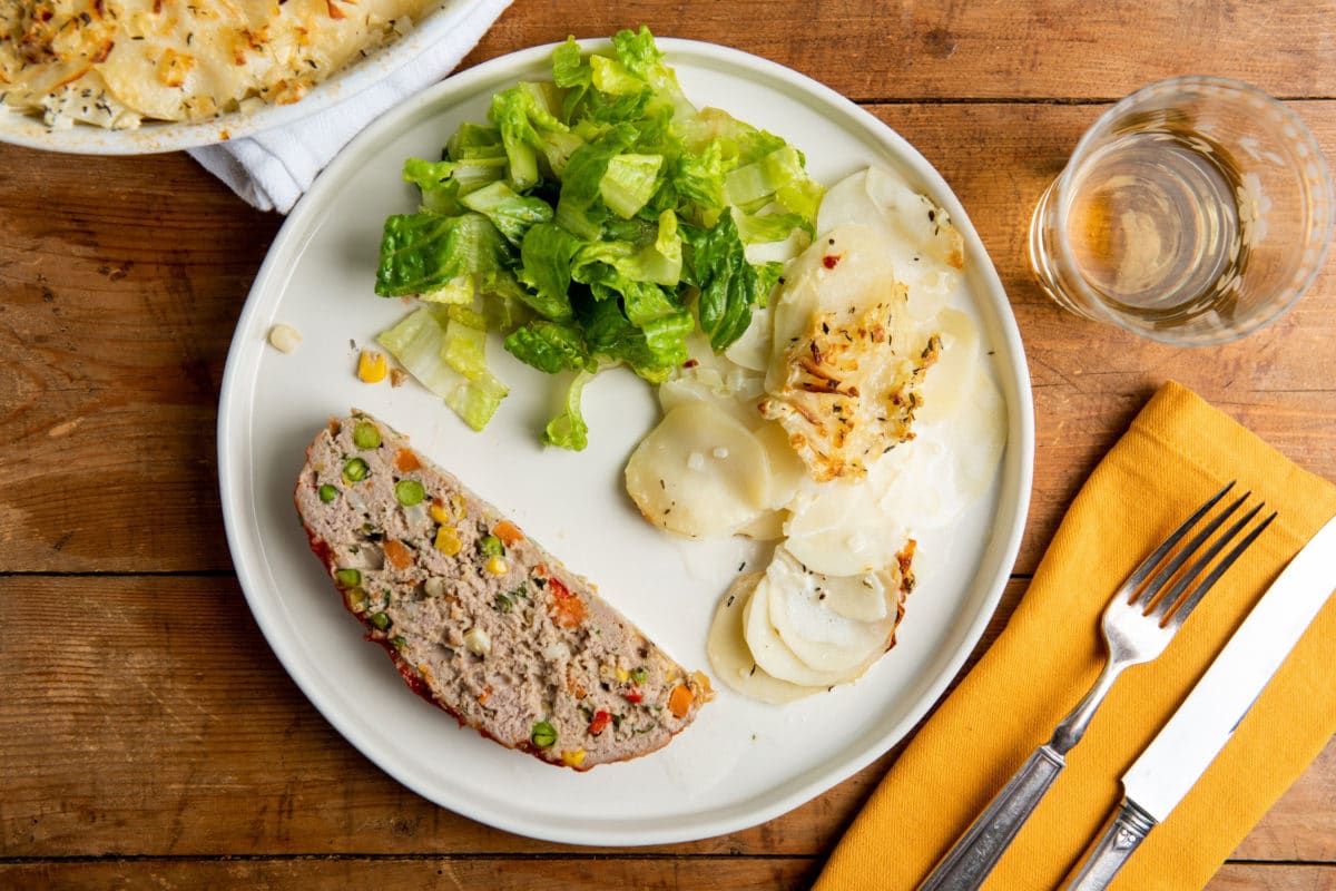 Vegetable Studded Turkey Meatloaf, potatoes, and salad on a white plate.