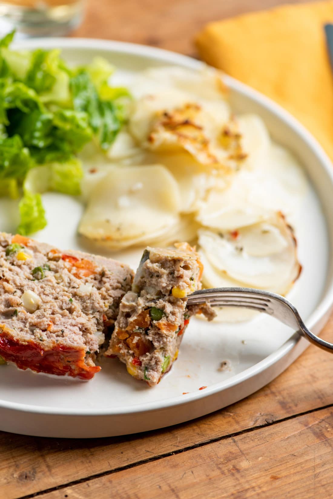 Fork grabbing a piece of Vegetable Studded Turkey Meatloaf.